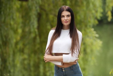 Portre hülyalı ve neşeli ve kaygısız güneşli güzel gülümseme ile varlık hava çekici genç kadın. Sağlıklı açık havada bir yaşam tarzı. Park dışında yaz veya bahar gününde mutlu kadın portre.