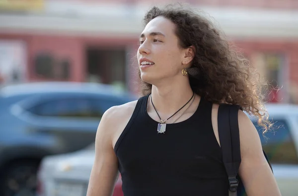 Outdoor portrait of modern young man walk street. Man with long curly hair. — Stock Photo, Image