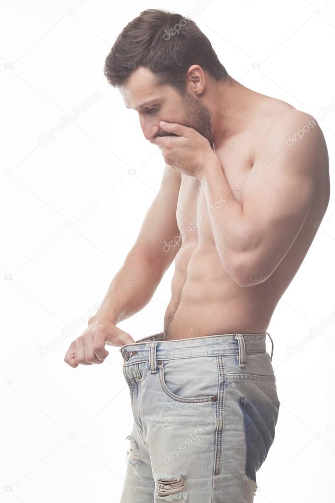 Attractive man is looking in his jeans - impotence concept