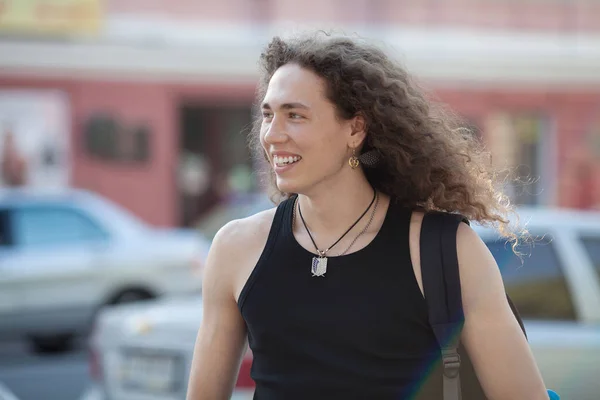 Outdoor portrait of modern young man walk street. Man with long curly hair. — Stock Photo, Image