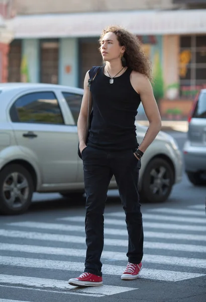 Außenporträt des modernen jungen Mannes zu Fuß Straße. Mann mit langen lockigen Haaren. — Stockfoto