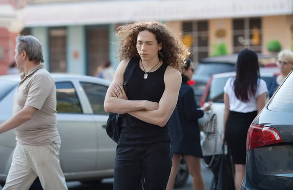 Ritratto all'aperto di giovane uomo moderno camminare strada. Uomo con lunghi capelli ricci . — Foto Stock