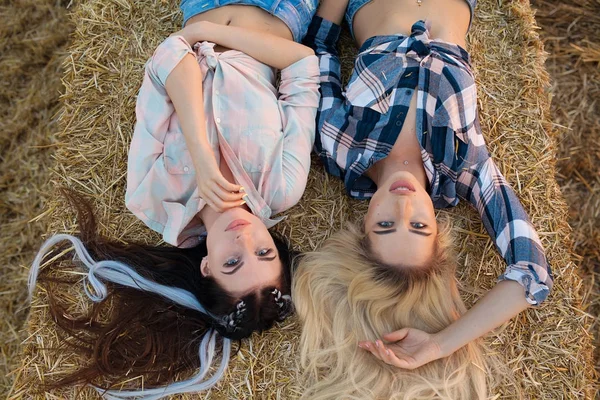 Two Happy girl on the hay. Sexy brunette and blonde women in field. — Stock Photo, Image