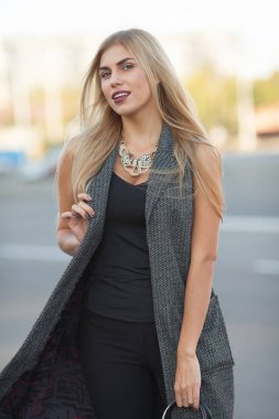 Açık sarı saçlı kolyesi oldukça güzel bir kadın portresi. Street şık kız.