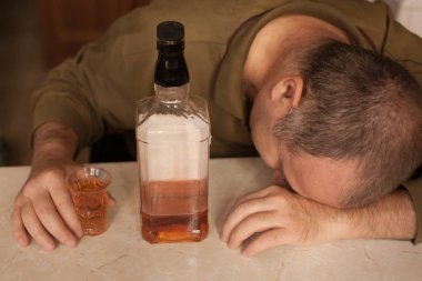 Masada Uyuyan adam alkol bağımlısı. Üzgün üzgün erkek yetişkin having zahmetli ile alkol.