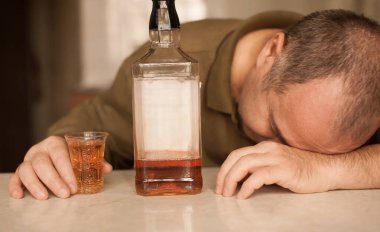 Masada Uyuyan adam alkol bağımlısı. Üzgün üzgün erkek yetişkin having zahmetli ile alkol.