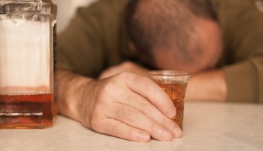 Masada Uyuyan adam alkol bağımlısı. Üzgün üzgün erkek yetişkin having zahmetli ile alkol.