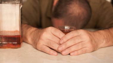 Masada Uyuyan adam alkol bağımlısı. Üzgün üzgün erkek yetişkin having zahmetli ile alkol.