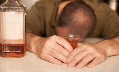 Masada Uyuyan adam alkol bağımlısı. Üzgün üzgün erkek yetişkin having zahmetli ile alkol.