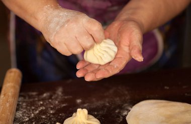 Hıngel, köfte, ellerimle yemek hamur et. büyük. Sulu et elinde kurulamak için baharatlı otlar ile bir hamur olarak. Lezzetli sıcak Georgian, Doğu, Buryat yemek. Poz veriyor, buzes, Hıngel ile et suyu.