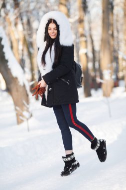 Beyaz kürklü kar taneleriyle gülümseyen güzel bir kadının kış portresi