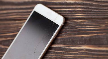Modern cep telefonu eski ahşap arka plan üzerinde kırık