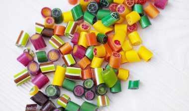 Renkli lolipoplar, baston şekerler ve tatlı şekerler ahşap arka planda karıştırılır.