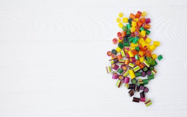 Renkli lolipoplar, baston şekerler ve tatlı şekerler ahşap arka planda karıştırılır.