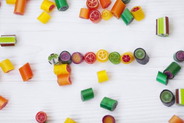 Renkli lolipoplar, baston şekerler ve tatlı şekerler ahşap arka planda karıştırılır.