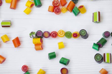 Renkli lolipoplar, baston şekerler ve tatlı şekerler ahşap arka planda karıştırılır.