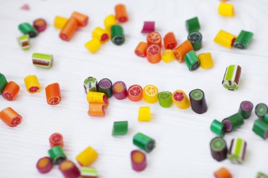 Renkli lolipoplar, baston şekerler ve tatlı şekerler ahşap arka planda karıştırılır.