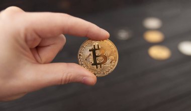 Altın Bitcoin siyah arka planda tutan adamın el