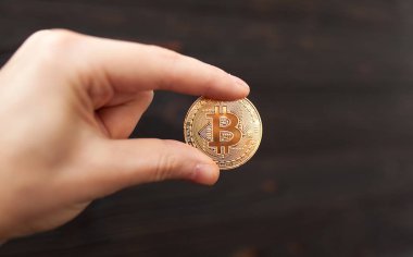 Altın Bitcoin siyah arka planda tutan adamın el