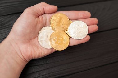 bitcoins, litecoin ve ethereum eski ahşap arka plan üzerinde elinde
