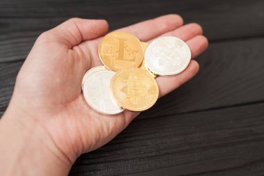 bitcoins, litecoin ve ethereum eski ahşap arka plan üzerinde elinde