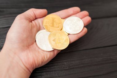 bitcoins, litecoin ve ethereum eski ahşap arka plan üzerinde elinde