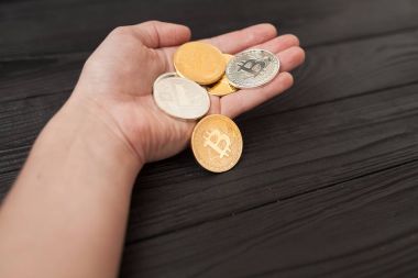bitcoins, litecoin ve ethereum eski ahşap arka plan üzerinde elinde