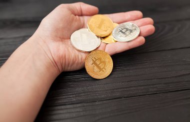 bitcoins, litecoin ve ethereum eski ahşap arka plan üzerinde elinde