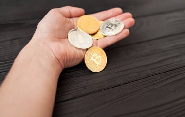 bitcoins, litecoin ve ethereum eski ahşap arka plan üzerinde elinde