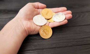bitcoins, litecoin ve ethereum eski ahşap arka plan üzerinde elinde