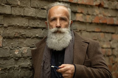 Uzun sakallı zarif beyefendi dışarıda sigara içiyor..