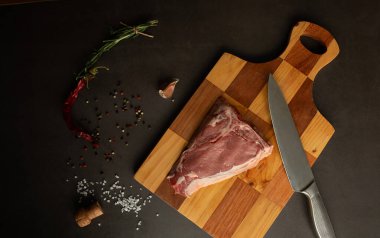 Çiğ biftek. Barbekü kaburga gözü bifteği ya da rustik masada biberiyeli biftek. T-Bone bifteği.