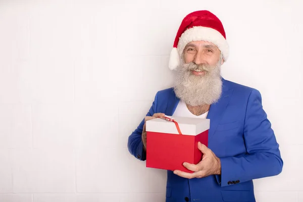 サンタ ハットで現代的な髭のビジネスマンが笑顔で贈り物を発表 — ストック写真