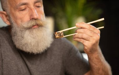 Sakallı yaşlı adam evde suşi yiyor..