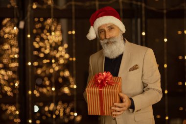 Noel Baba şapkalı iş adamı elinde bir hediyeyle. Xmas.