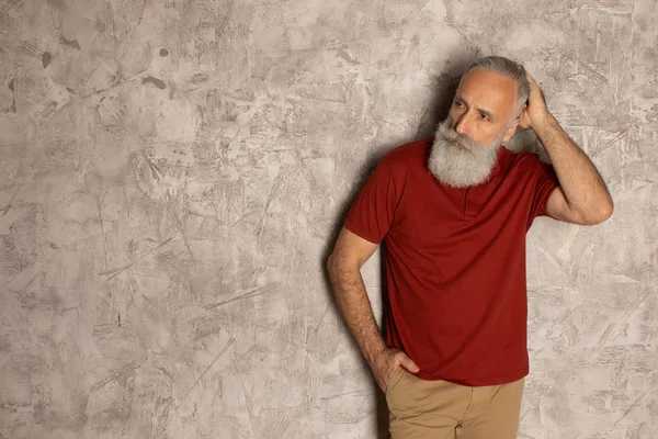 Perfect beard. Close-up of senior bearded man standing against grey background.