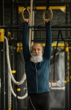 Ciddi olgun erkek yoğun egzersiz spor salonunda geçiriyor.