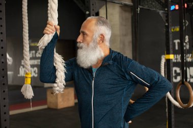 Ciddi olgun erkek yoğun egzersiz spor salonunda geçiriyor.