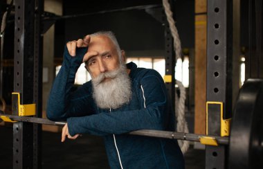 Formda sakallı kıdemli adam antrenmandan sonra dinleniyor..