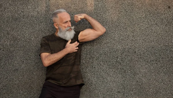Fit older man flexing his biceps.