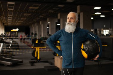 Ciddi olgun erkek yoğun egzersiz spor salonunda geçiriyor.