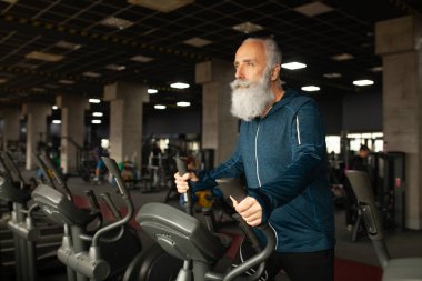 Spor salonundaki koşu makinesindeki son sınıf sakallı adam. Koşu bandı. 