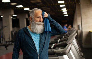 Formda sakallı kıdemli adam antrenmandan sonra dinleniyor..