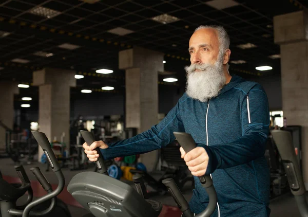Spor salonundaki koşu makinesindeki son sınıf sakallı adam. Koşu bandı. 