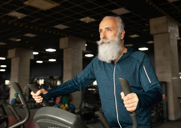 Spor salonundaki koşu makinesindeki son sınıf sakallı adam. Koşu bandı. 