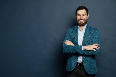 Mavi gömlek giyen yakışıklı bir adam ve mavi arka planda izole edilmiş moda bir ceket..