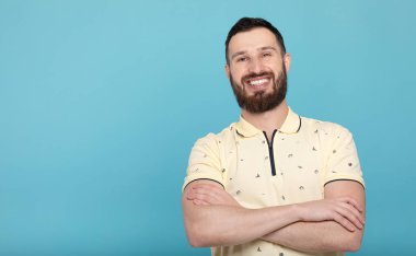 Portrait of a handsome bearded man smiling looking to the camera on blue background.