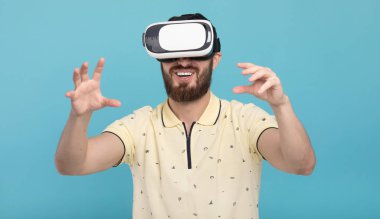 Genç adam dokunmaya çalışıyorum Vr gözlük kulaklık kullanarak sanal gerçeklik nesneleri. İzole beyaz arka plan.