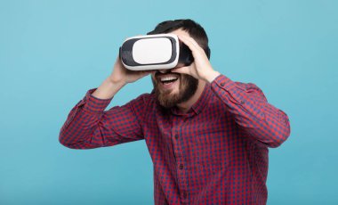 Genç sakallı adam sanal gerçeklik kulaklığı kullanıyor. VR, gelecek, cihazlar, teknoloji konsepti.