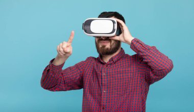 Genç sakallı adam sanal gerçeklik kulaklığı kullanıyor. VR, gelecek, cihazlar, teknoloji konsepti.